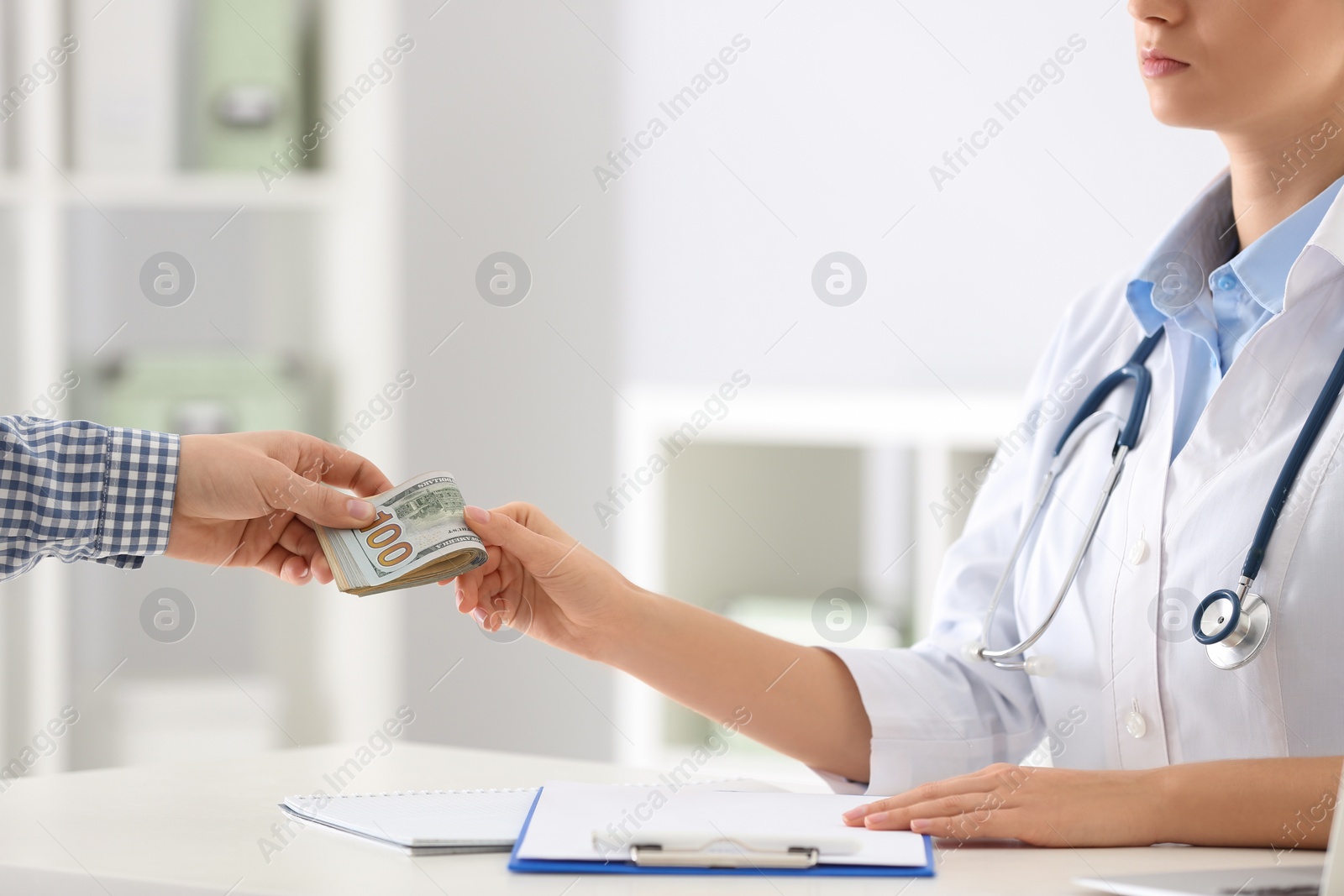 Photo of Patient giving bribe to doctor in clinic, closeup. Corrupted medicine