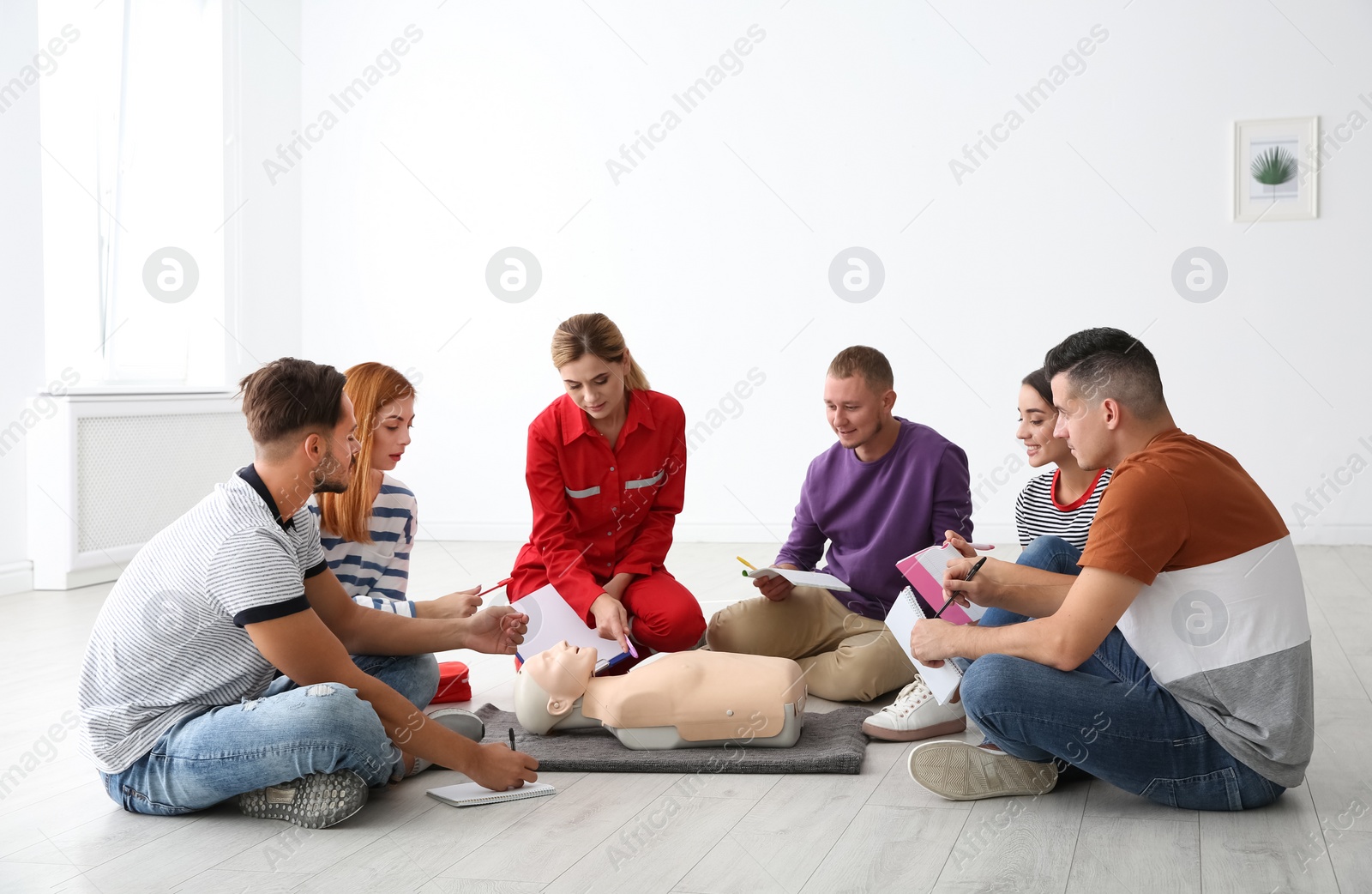 Photo of Group of people with instructor at first aid class indoors