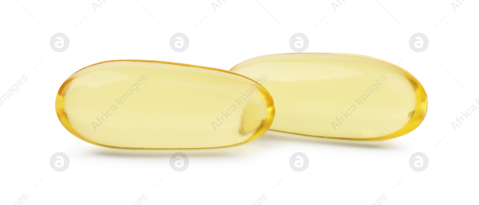 Photo of Two yellow vitamin capsules isolated on white