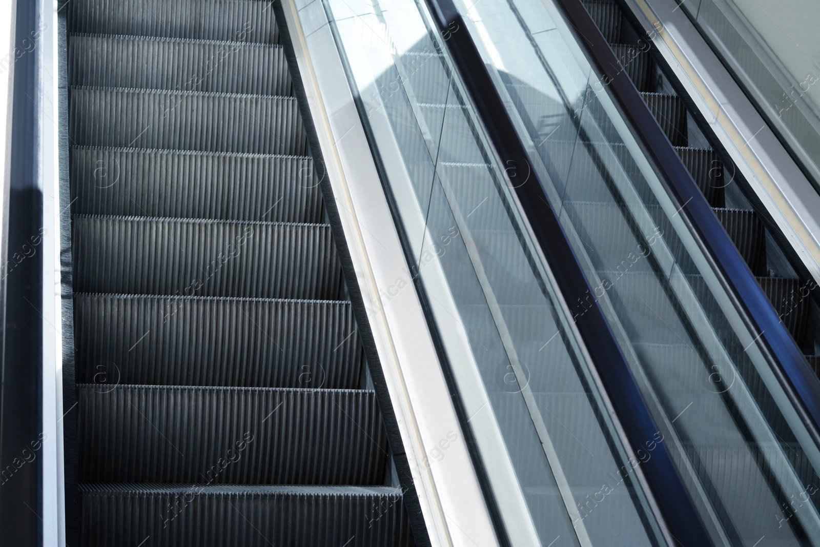 Photo of Modern escalators with handrails in shopping mall, closeup