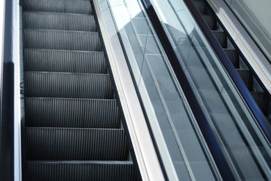 Photo of Modern escalators with handrails in shopping mall, closeup