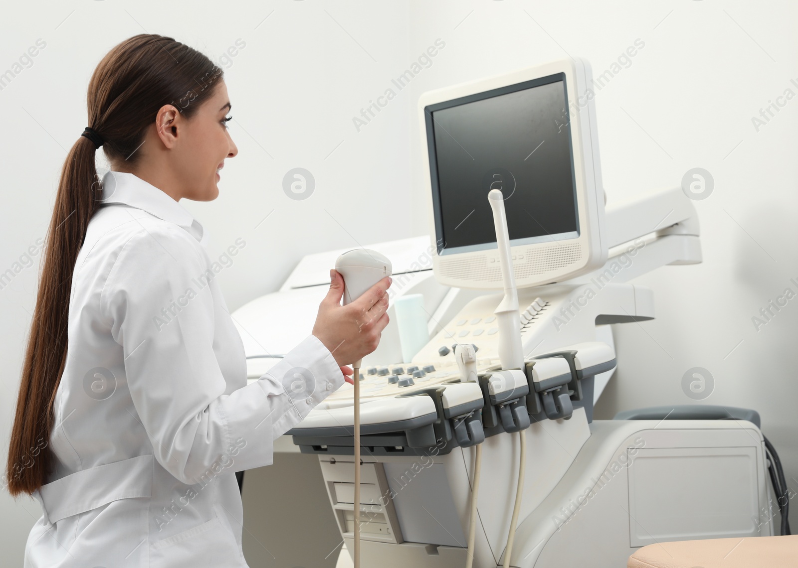 Photo of Professional sonographer using modern ultrasound machine in clinic