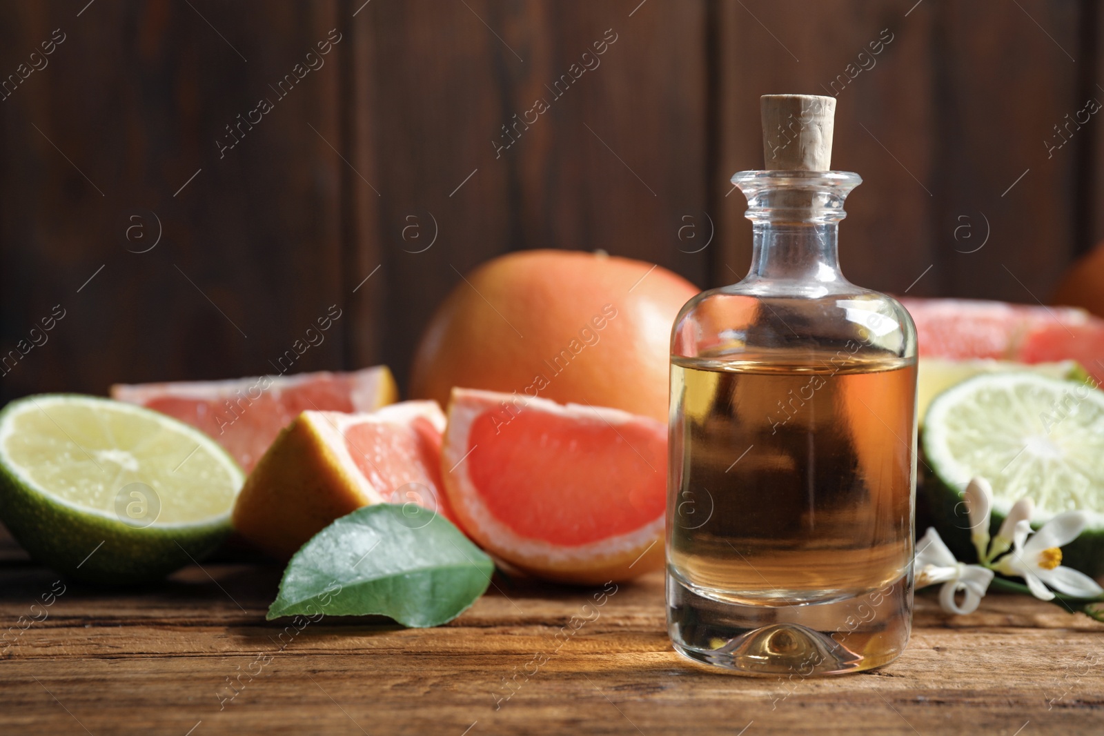 Photo of Citrus essential oil on wooden table. Space for text