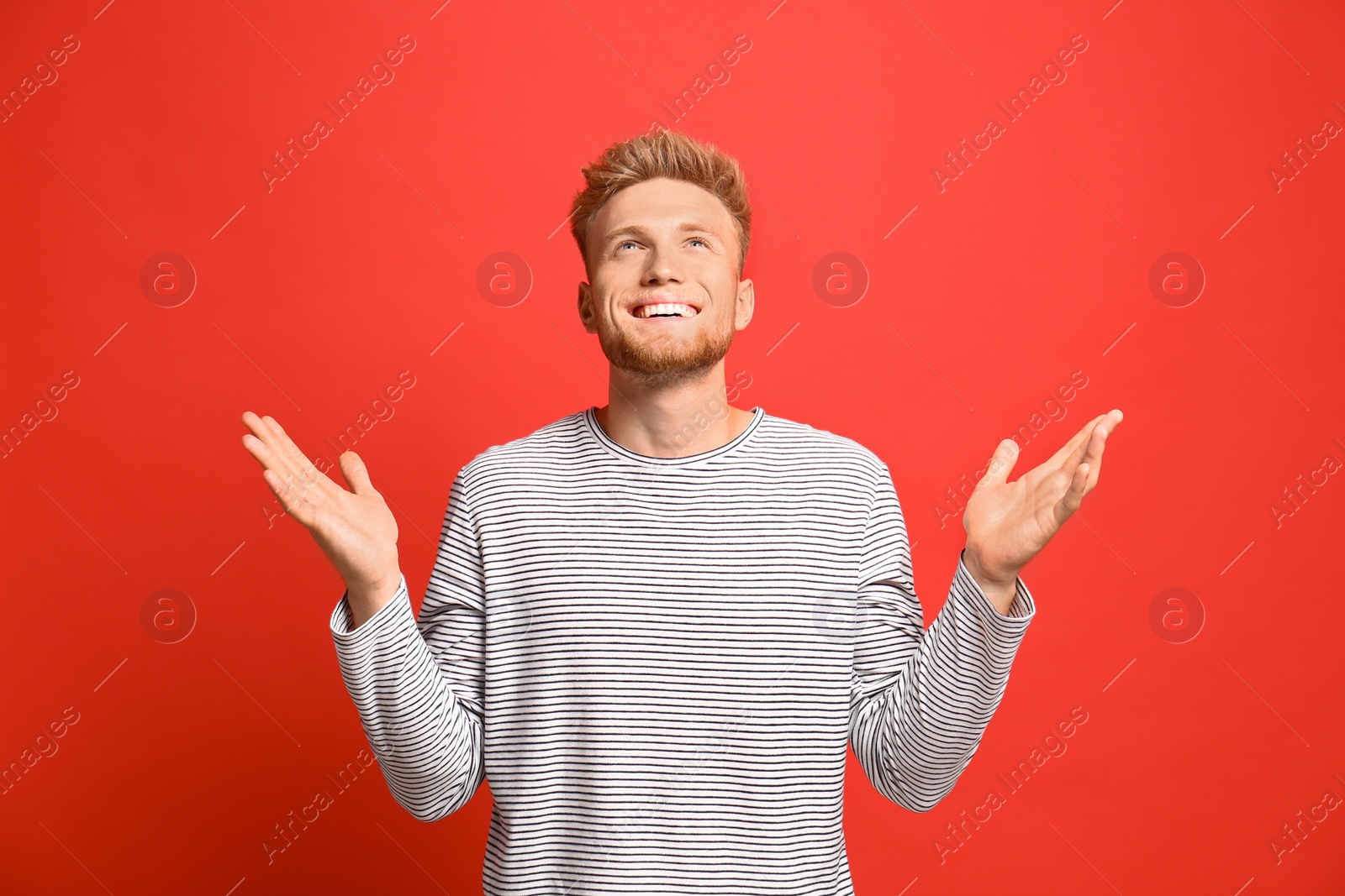 Photo of Portrait of happy young man on red background