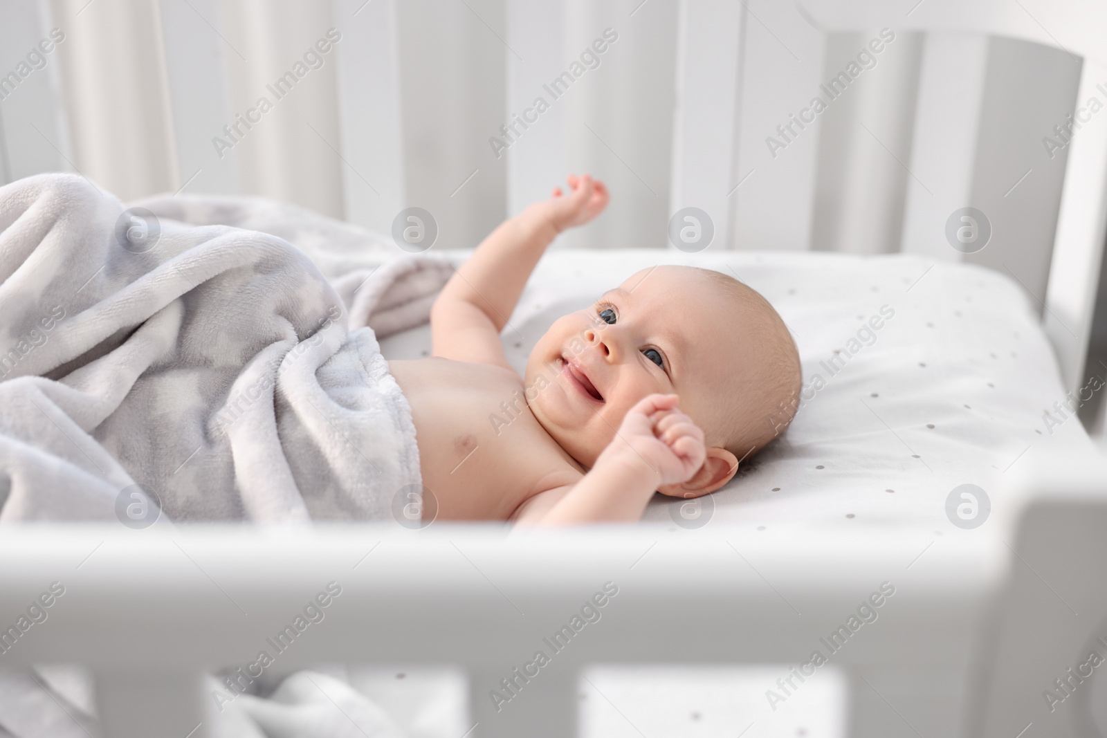 Photo of Cute little baby lying in crib at home