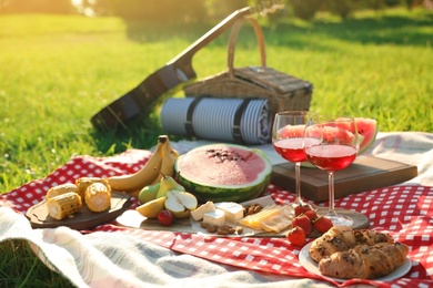 Picnic blanket with delicious food and drinks outdoors on sunny day