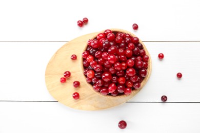 Photo of Fresh ripe cranberries in bowl on white wooden table, top view