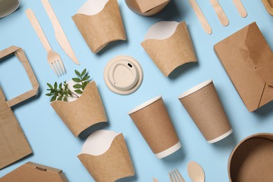 Flat lay composition with eco friendly food packagings and twigs on light blue background