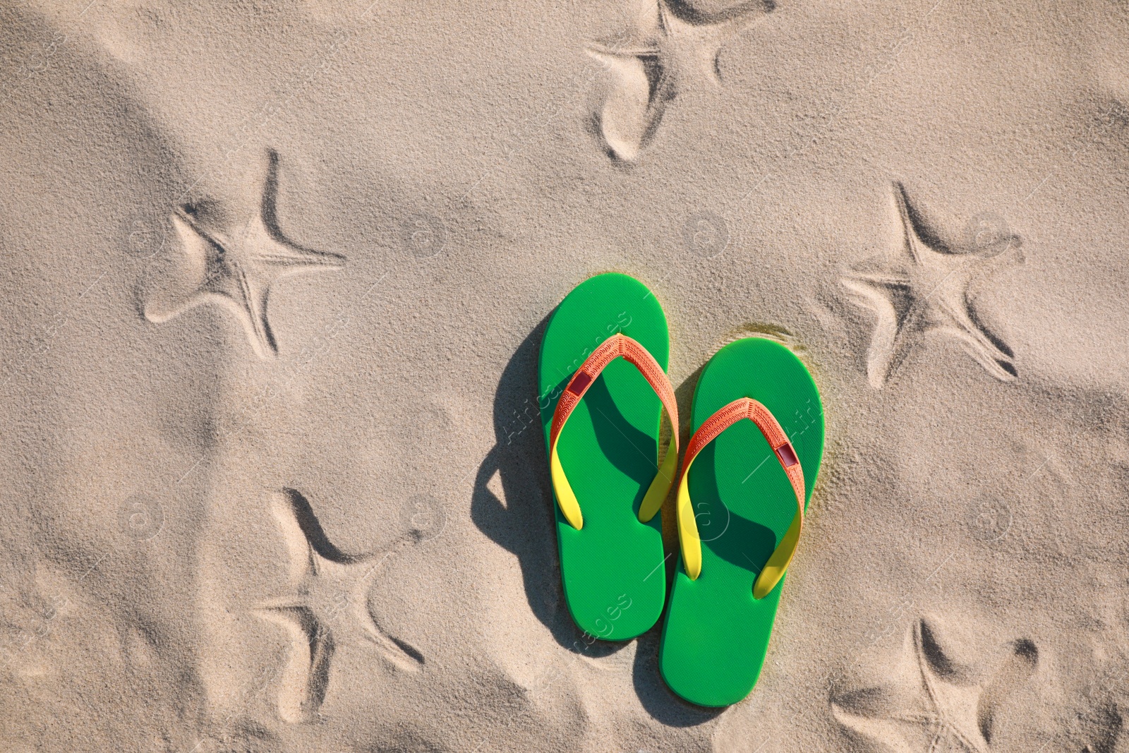 Photo of Stylish flip flops on beach, top view. Space for text