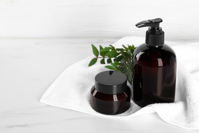 Shampoo bottle, hair mask and towel on white marble table, space for text