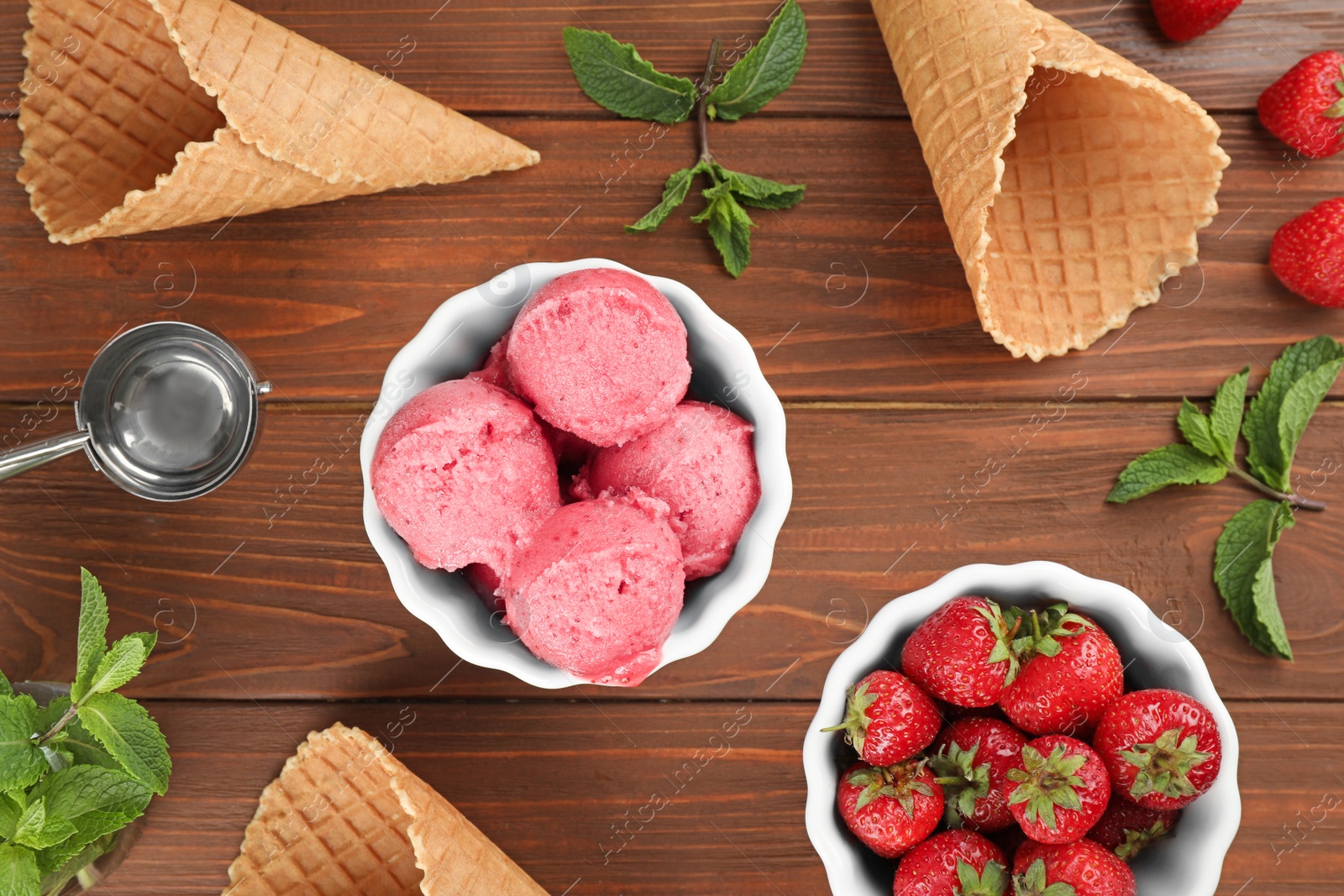 Photo of Flat lay composition with delicious strawberry ice cream on wooden table