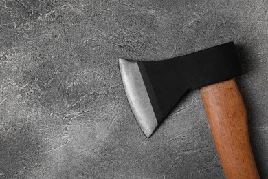 Photo of Metal axe with wooden handle on grey textured table, top view. Space for text