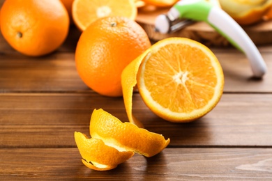 Photo of Orange fruits with peel on wooden table