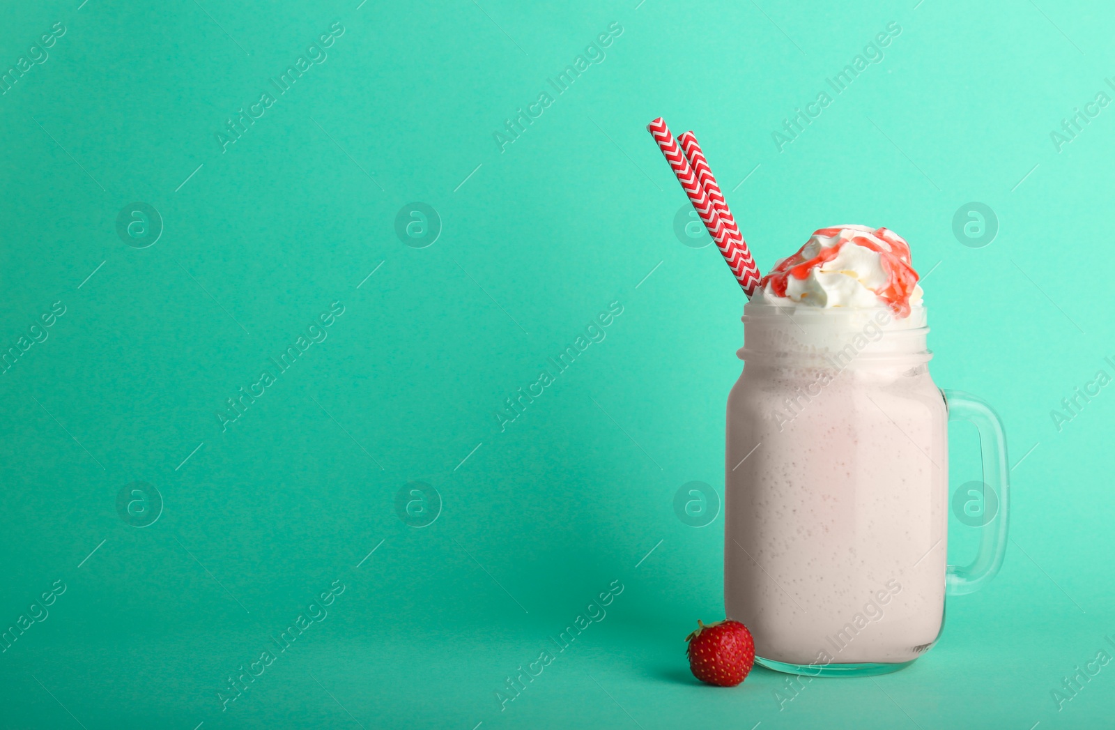 Photo of Mason jar with delicious milk shake on color background