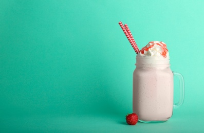 Mason jar with delicious milk shake on color background