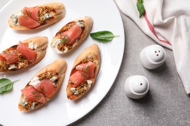 Flat lay composition with tasty bruschettas on grey table