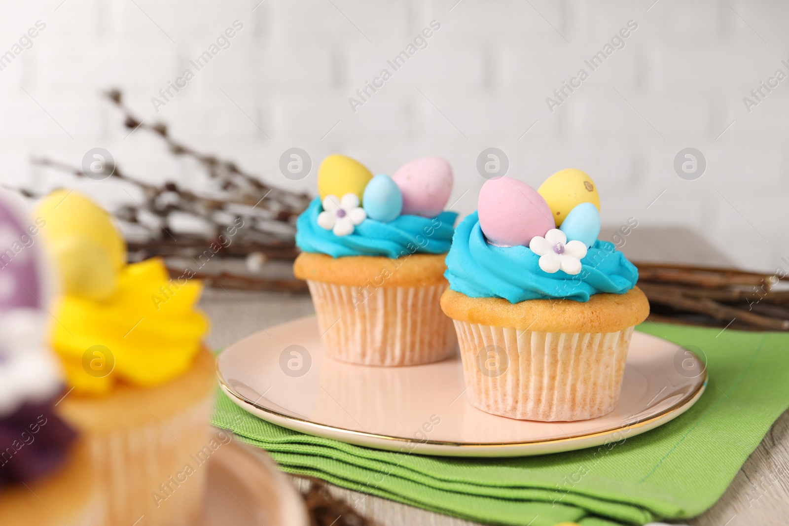 Photo of Tasty decorated Easter cupcakes on wooden table