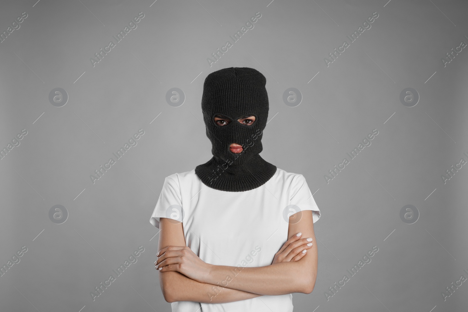 Photo of Woman wearing knitted balaclava on grey background