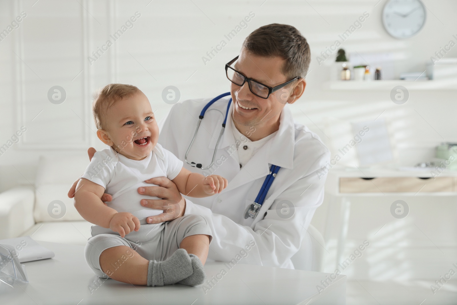 Photo of Pediatrician examining cute little baby in clinic