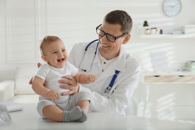 Photo of Pediatrician examining cute little baby in clinic