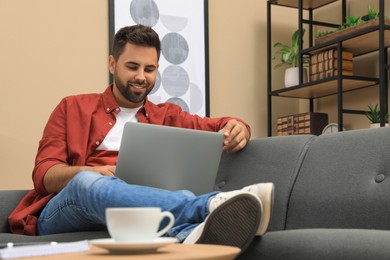 Photo of Man using laptop for online shopping at home