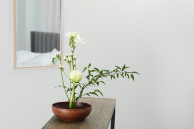 Photo of Stylish ikebana with beautiful flowers and green branch carrying cozy atmosphere at home