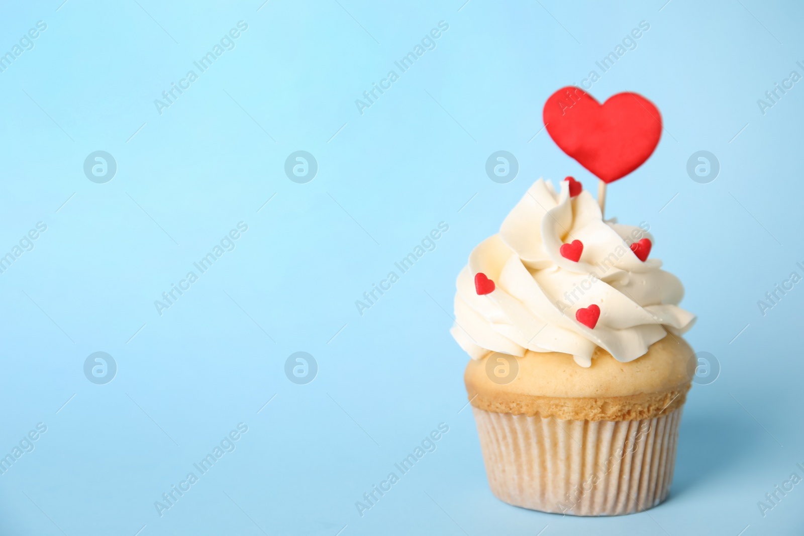 Photo of Tasty cupcake on light blue background, space for text. Valentine's Day celebration