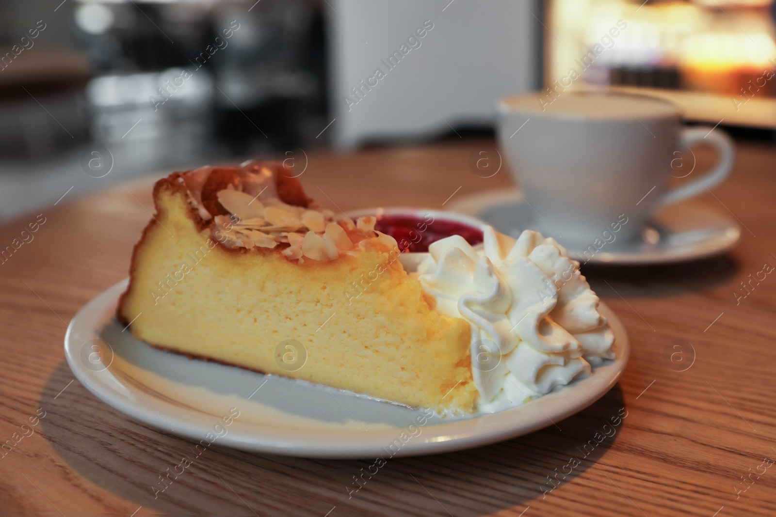 Photo of Delicious dessert and cup of aromatic coffee on wooden table in cafe, closeup