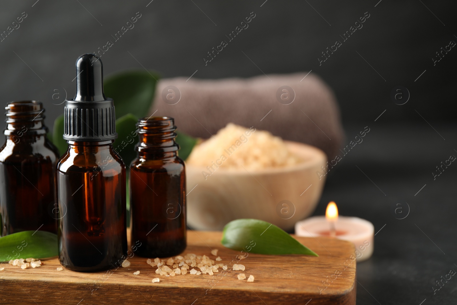 Photo of Composition with aroma oil bottles on grey table, space for text