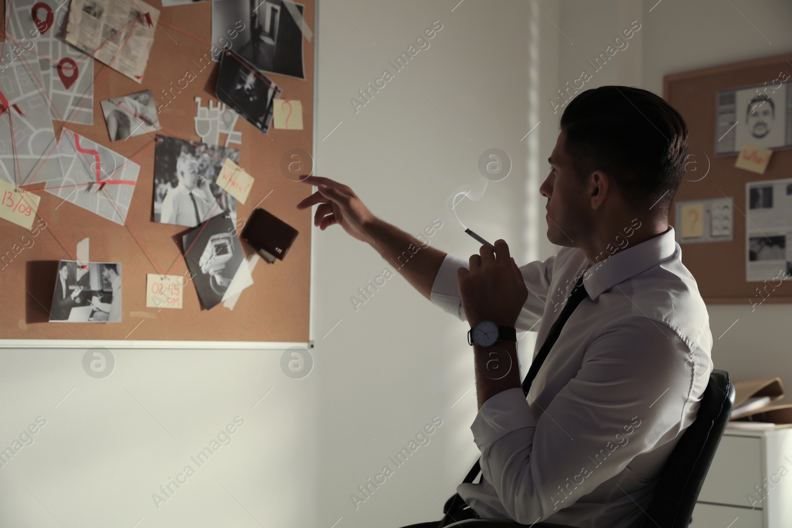 Photo of Detective looking at evidence board in office