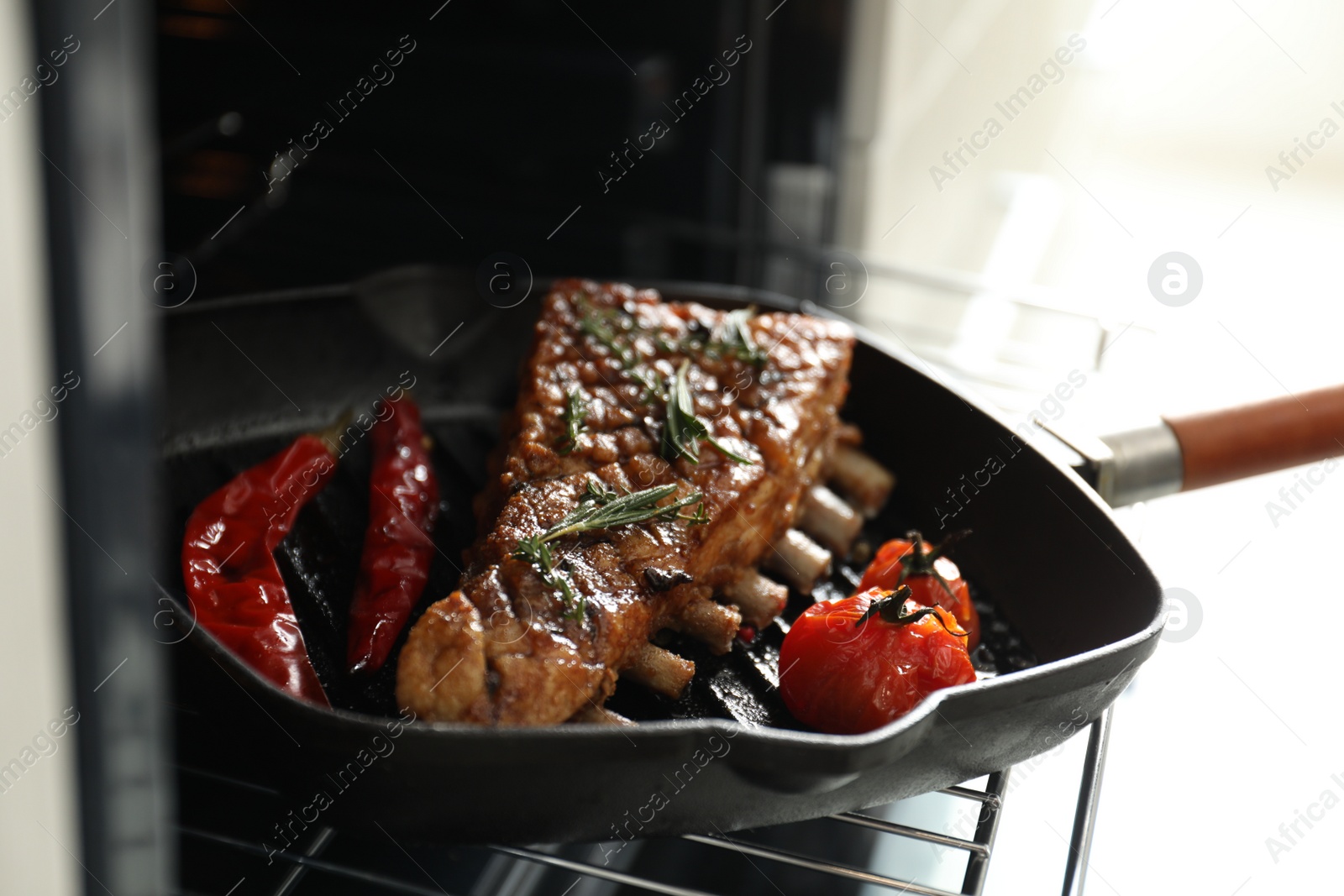 Photo of Delicious roasted ribs on pan in oven