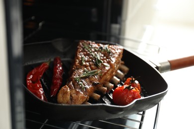 Photo of Delicious roasted ribs on pan in oven