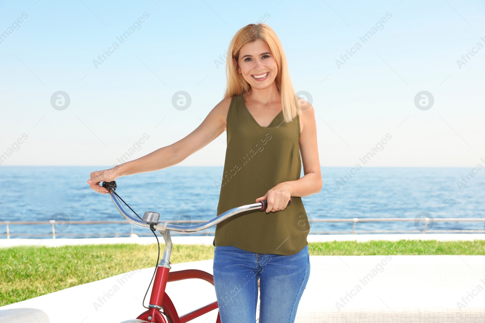 Photo of Attractive woman with bike near sea on sunny day