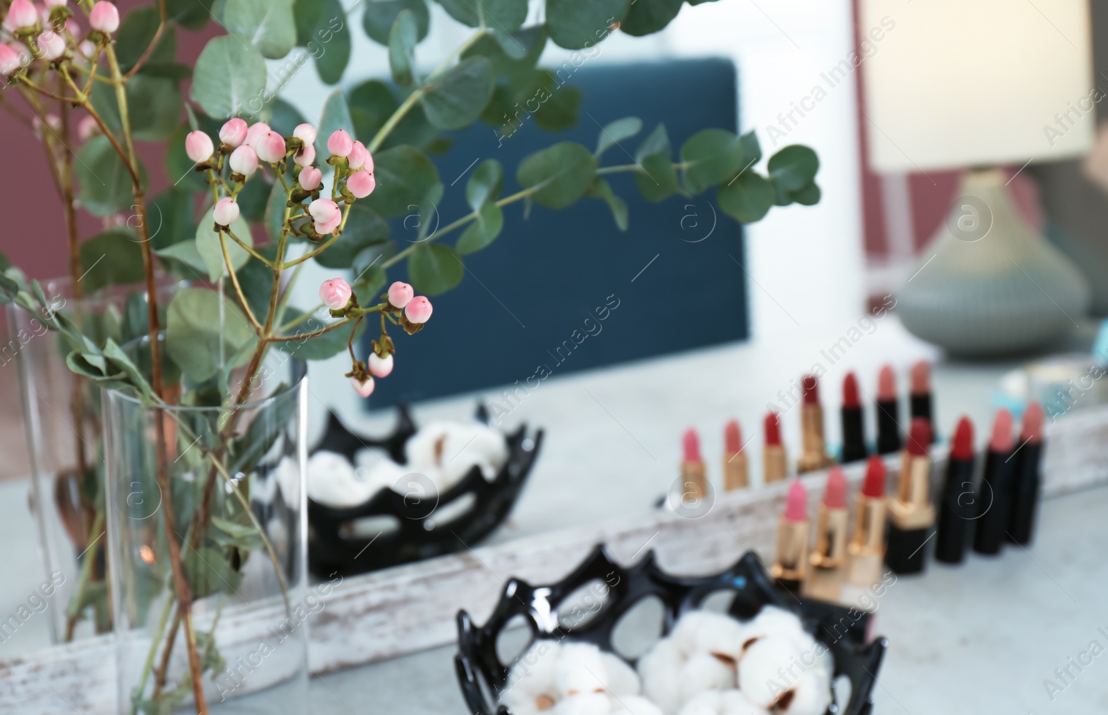 Photo of Vase with flowers on dressing table in makeup room, closeup