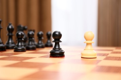 Photo of Black and white pieces among others on chessboard indoors