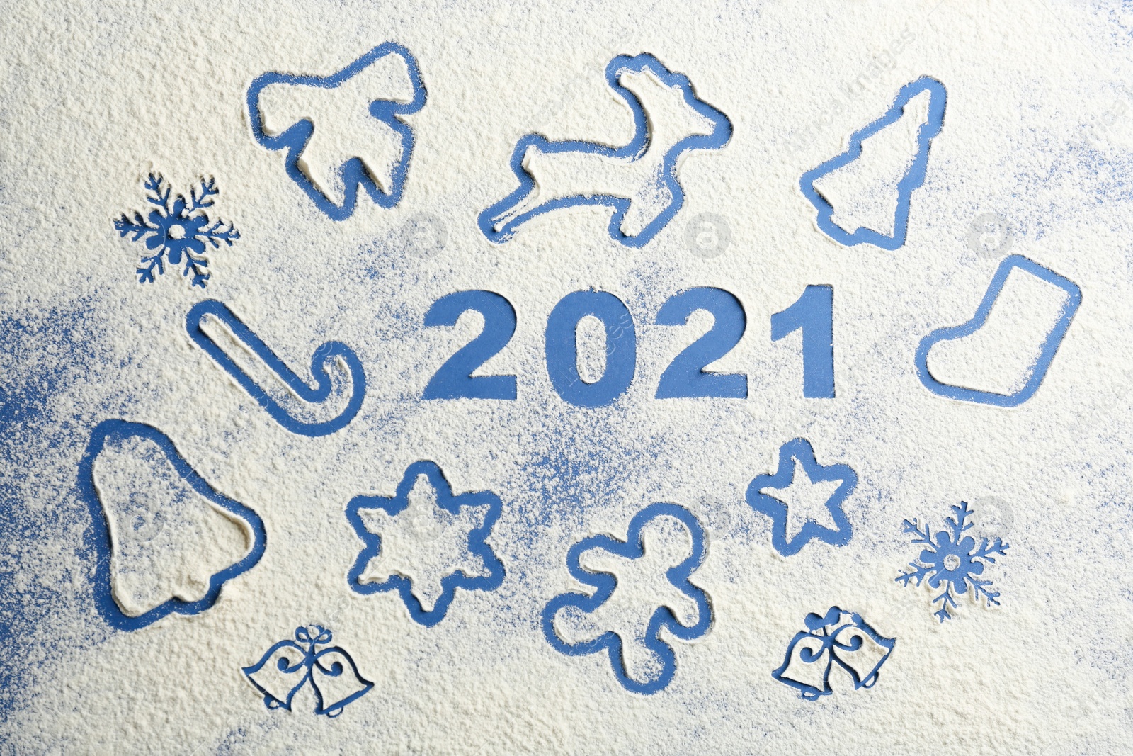 Photo of Number 2021 and different Christmas cookie shapes made of flour on blue background, top view