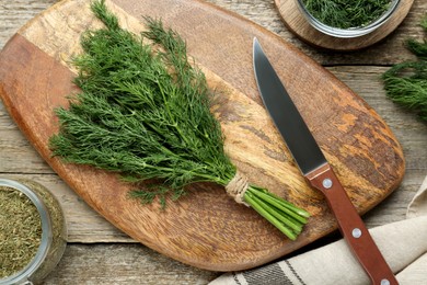 Photo of Fresh dill preparing for drying on wooden table, flat lay