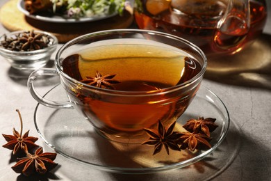Photo of Aromatic tea with anise stars on light grey table, closeup