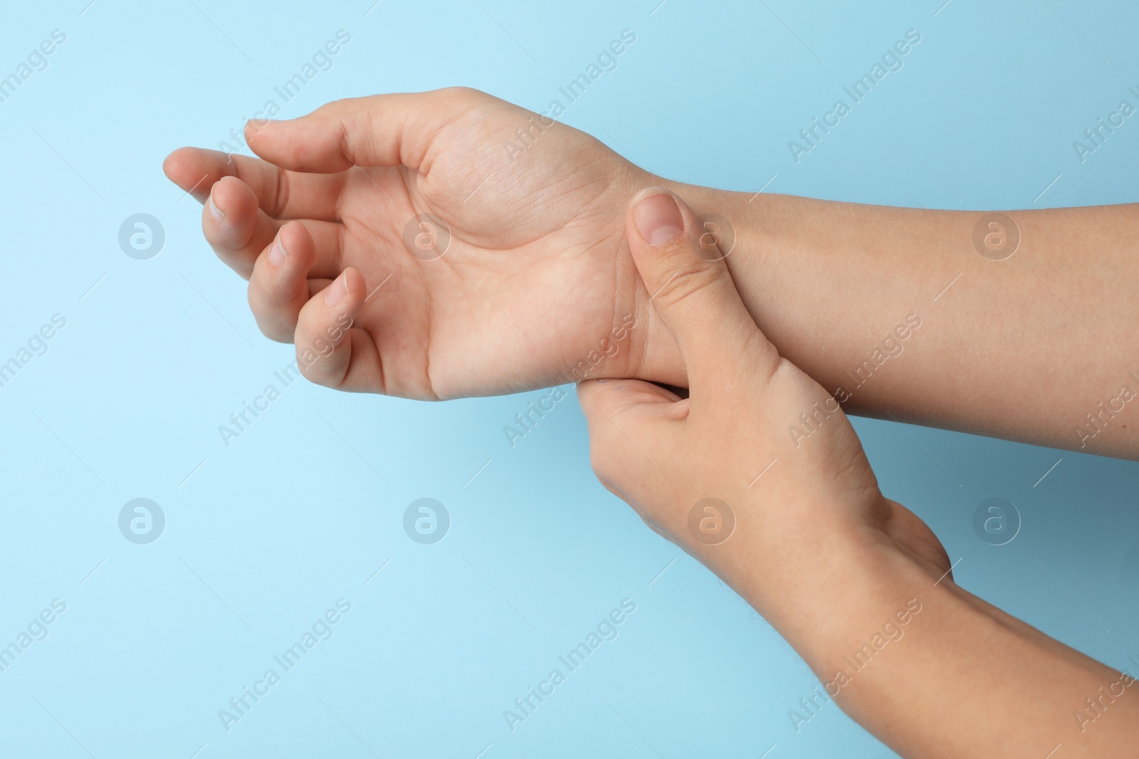 Photo of Woman checking pulse on color background, closeup