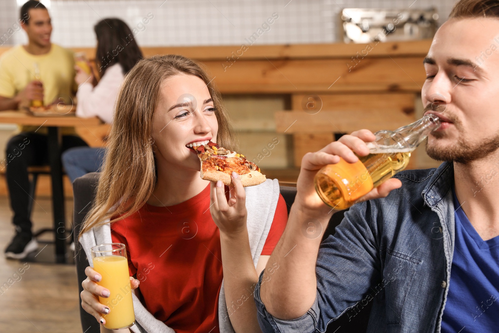 Photo of Young couple eating delicious pizza in cafe