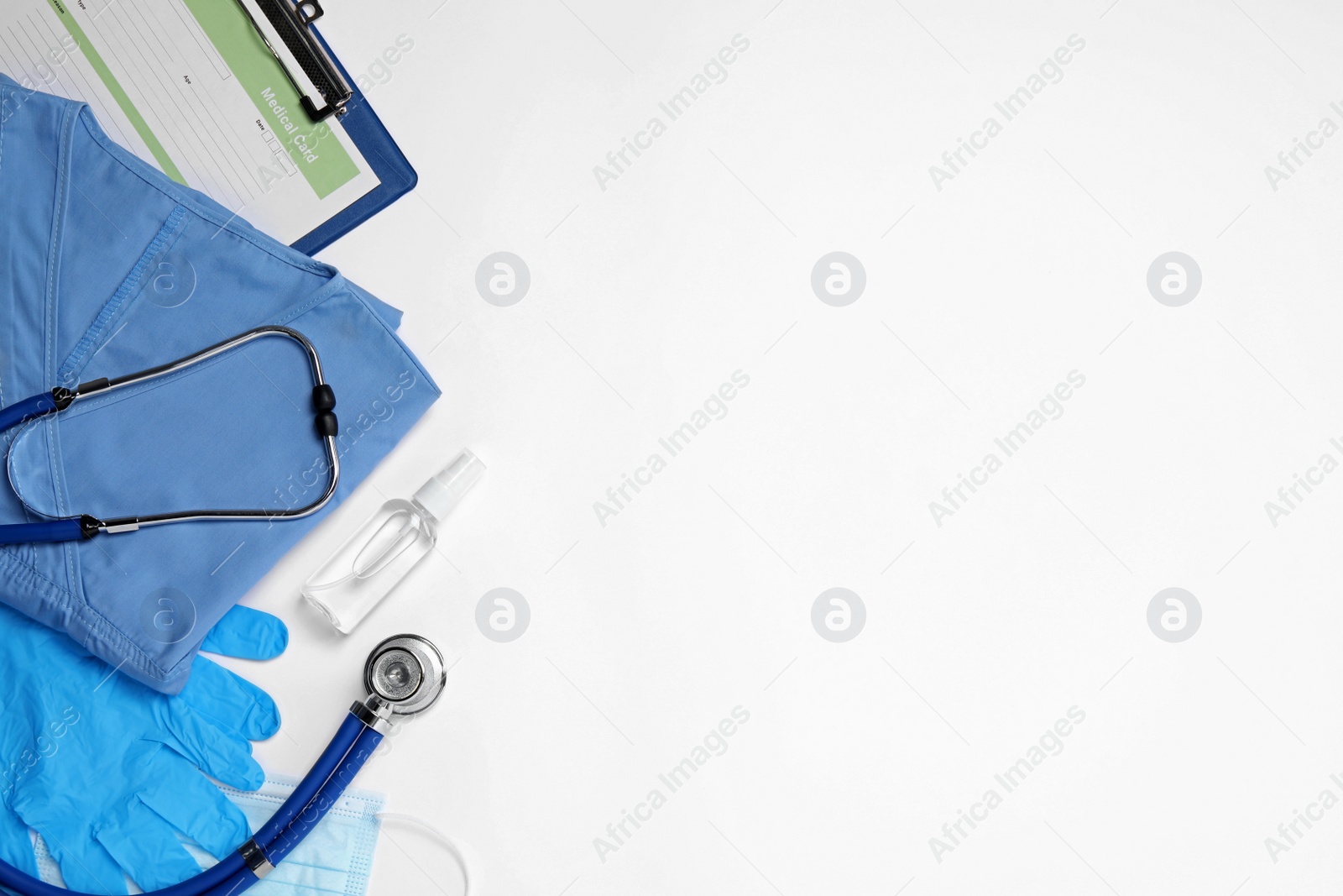 Photo of Flat lay composition with medical uniform and clipboard on white background. Space for text