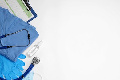 Flat lay composition with medical uniform and clipboard on white background. Space for text