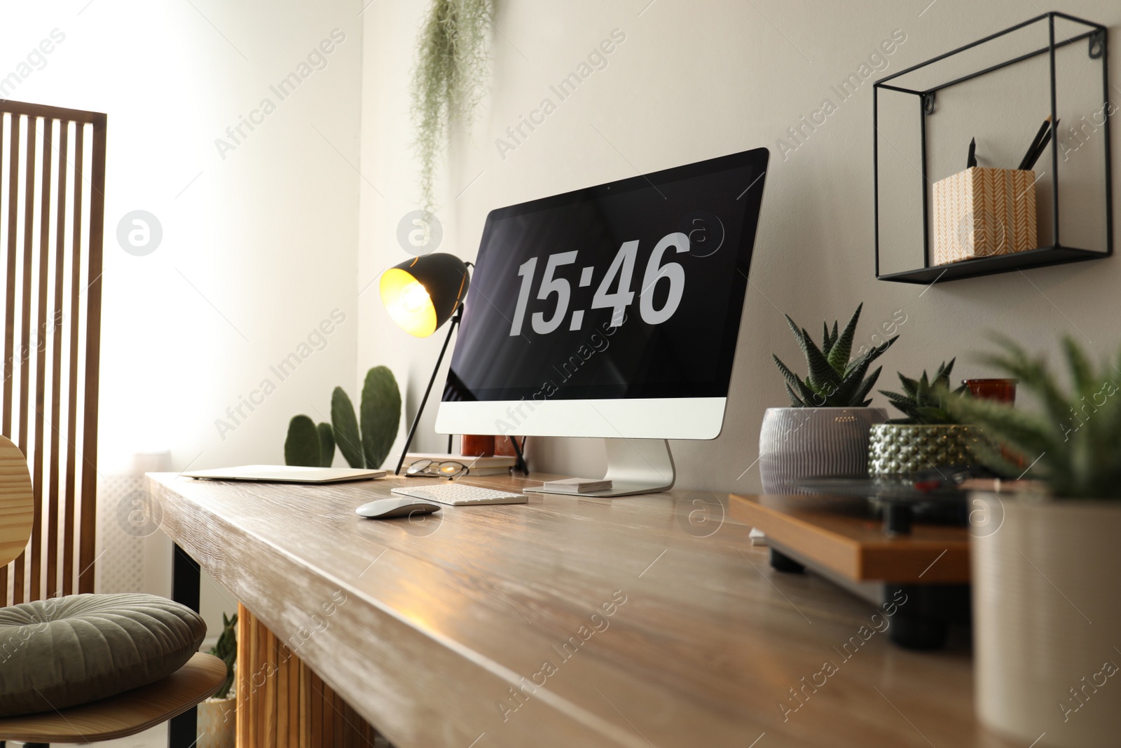 Photo of Modern computer and laptop on wooden desk in room. Interior design