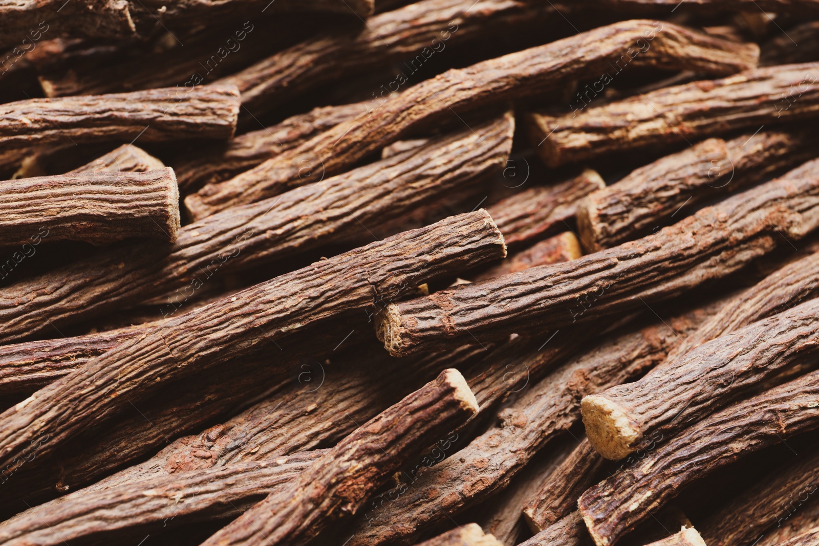 Photo of Dried sticks of liquorice root as background, closeup