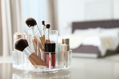 Organizer with makeup cosmetic products on table indoors. Space for text