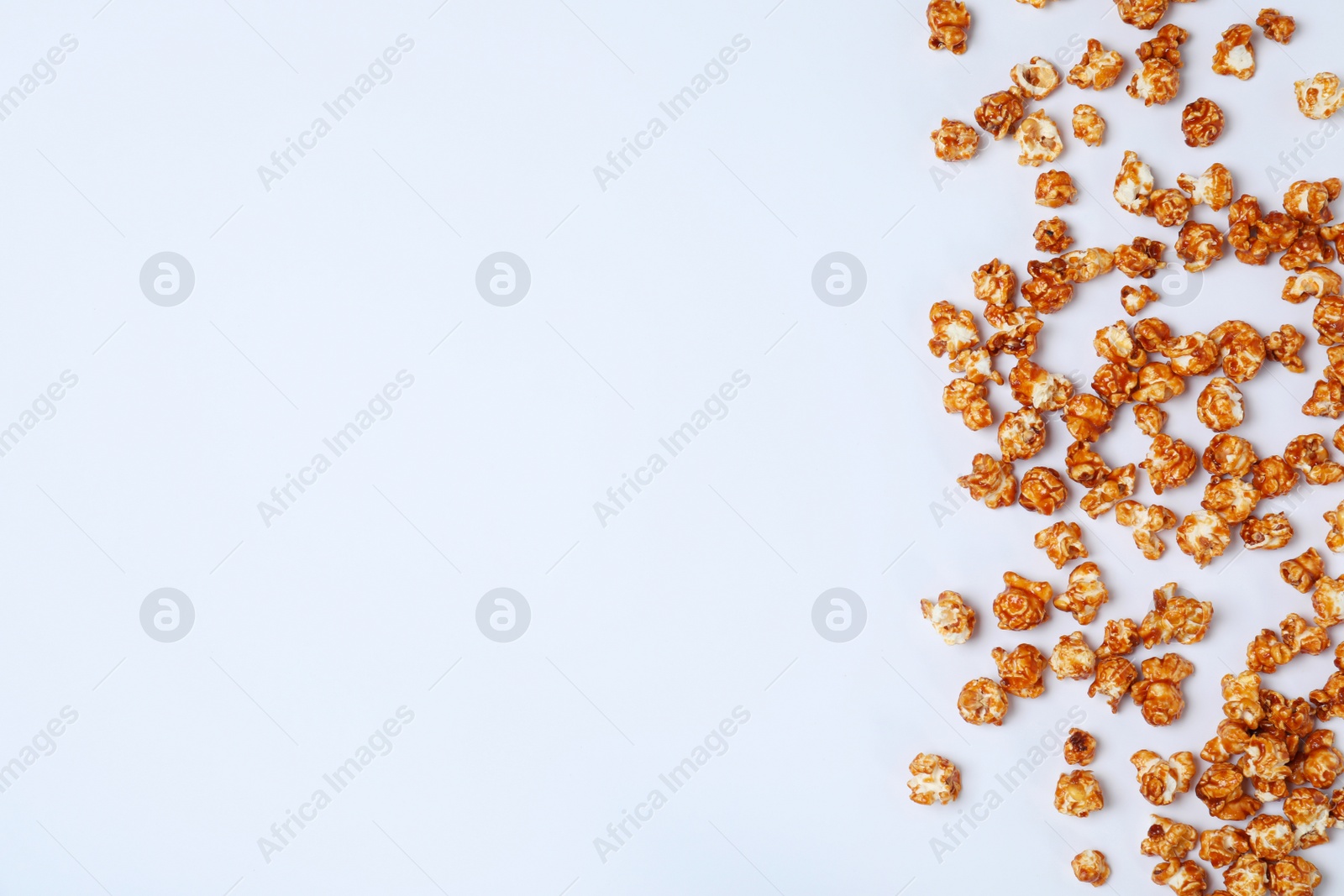 Photo of Flat lay composition with caramel popcorn and space for text on white background