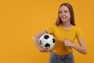 Photo of Happy sports fan with ball on yellow background. Space for text