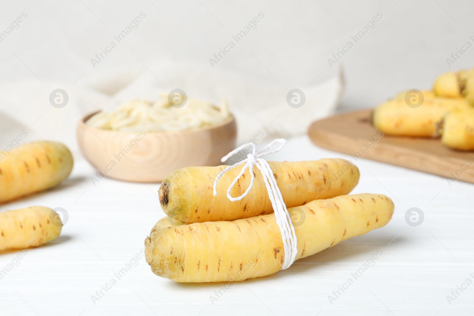 Photo of Fresh raw white carrots on wooden table