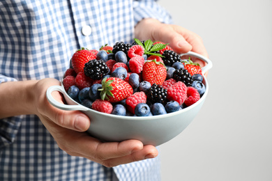 Photo of Woman with bowl of delicious summer berries, closeup