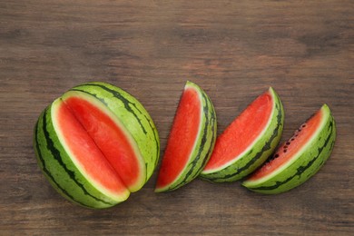 Photo of Delicious cut watermelons on wooden table, flat lay